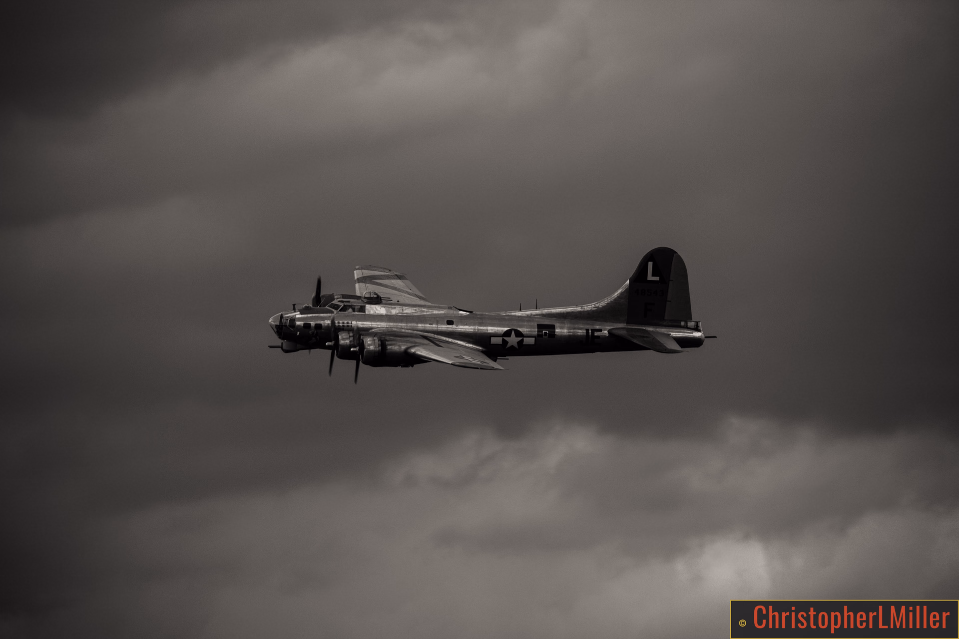Vintage B-17 bomber flying against dramatic storm clouds at Goshen Airshow 2017.